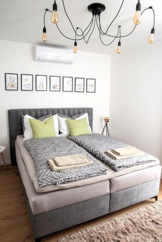 a bed in a bedroom with a chandelier at Icon of Balaton in Balatonkenese
