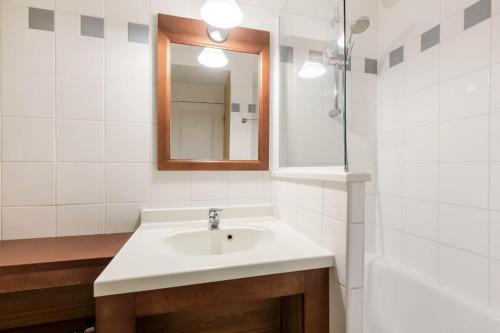 une salle de bain blanche avec un lavabo et un miroir dans l'établissement Résidence Les Grands Pins - maeva Home - Appartement 2 pièces 4 personnes - Sélection MAE-7104, à Maubuisson