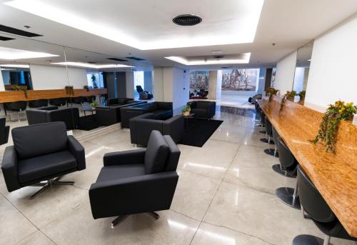 a waiting room with chairs and a long bar at Hotel Nacional Inn Jaragua Sao Paulo in Sao Paulo