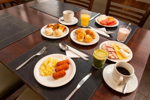a table with plates of breakfast food on it at Hotel Nacional Inn Jaragua Sao Paulo in Sao Paulo