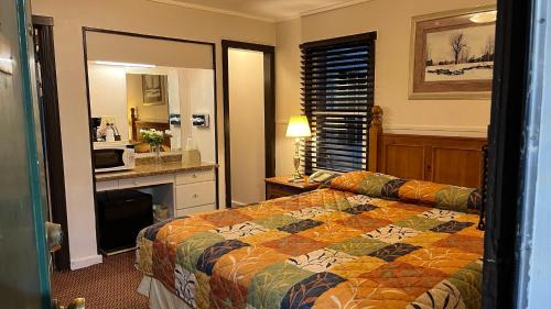 a hotel room with a bed and a kitchen at Jumping Frog Motel in Angels Camp