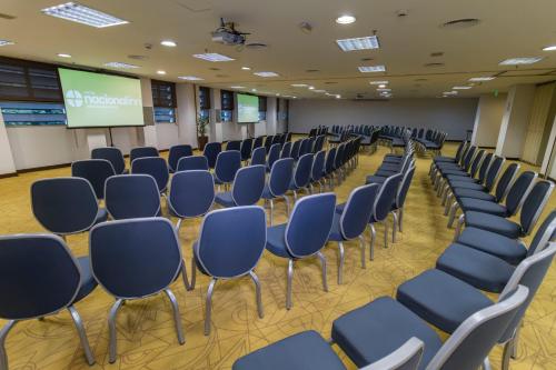 a conference room with blue chairs and a screen at Hotel Nacional Inn Jaragua Sao Paulo in Sao Paulo