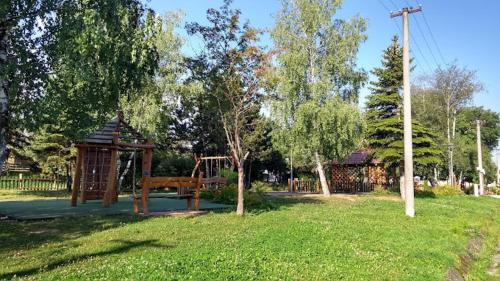 park z placem zabaw z drewnianą huśtawką w obiekcie Apartment My Way w Popradzie