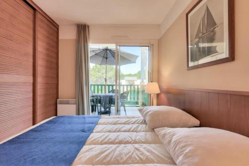 une chambre avec un lit et un balcon dans l'établissement Résidence Les Grands Pins - maeva Home - Appartement 2 pièces 4 personnes - Sélection MAE-7914, à Maubuisson