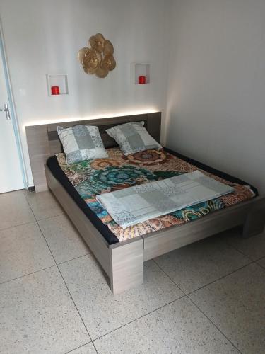 un lit dans une chambre avec un cadre de lit dans l'établissement chambre dans une appartement la belle de mai, à Marseille