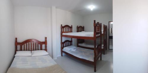 a room with two bunk beds and a mirror at Pousada Sophia Beach in Salinópolis