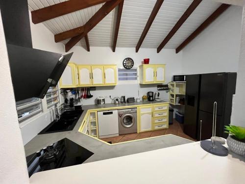 a kitchen with yellow cabinets and a counter top at Mango Sea -Villa "Maracudja" et appartement "Jojoba" avec piscine & vue sur les îles in Saint-François