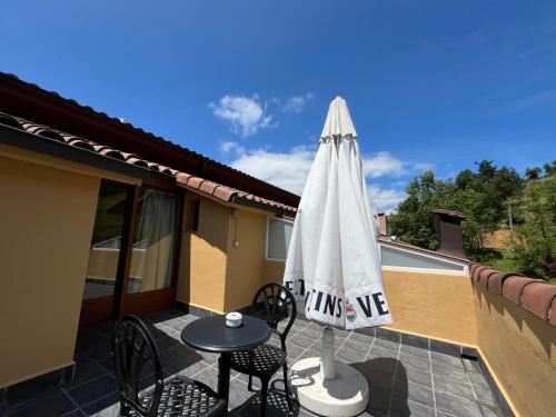 a patio with an umbrella and a table and chairs at Hotel Larrañaga in Azpeitia