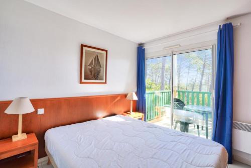 une chambre avec un lit et une fenêtre avec un balcon dans l'établissement Résidence Les Grands Pins - maeva Home - Appartement 2 pièces 5 personnes - Prestige MAE-3024, à Maubuisson