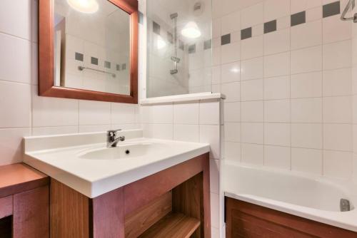 a bathroom with a sink and a bath tub at Résidence Les Grands Pins - maeva Home - Appartement 2 pièces 5 personnes - Confort MAE-0384 in Maubuisson