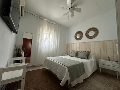 ein Schlafzimmer mit einem Bett und einem Deckenventilator in der Unterkunft Susurros del Mar in Conil de la Frontera