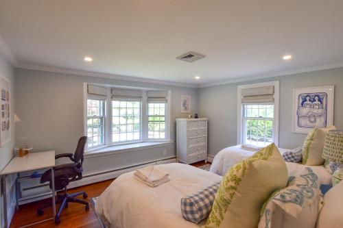 a room with two beds and a desk and a couch at Swing Set Plunge pool and large yard await in Barnstable