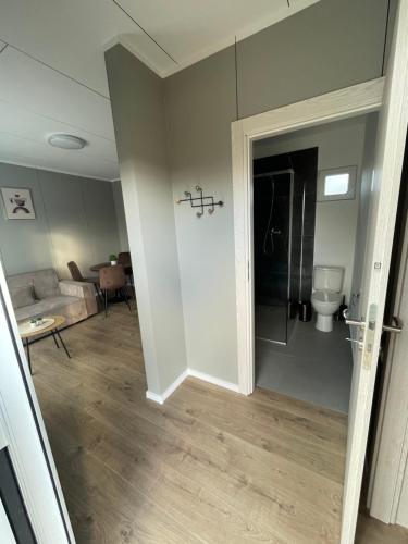 una porta aperta su un soggiorno con un bagno di Jaukus Namelis Šventojoje a Palanga