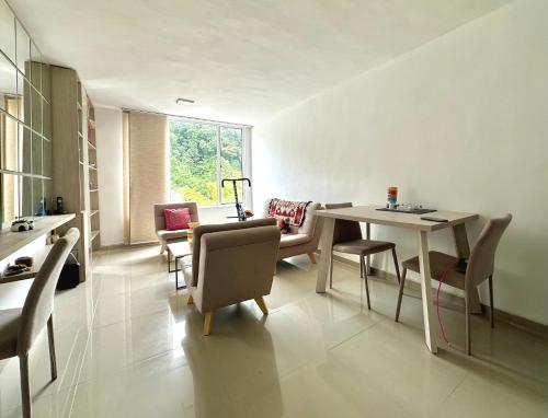 un salon avec une table et des chaises de salle à manger dans l'établissement Tú hogar, tú tranquilidad, à Manizales