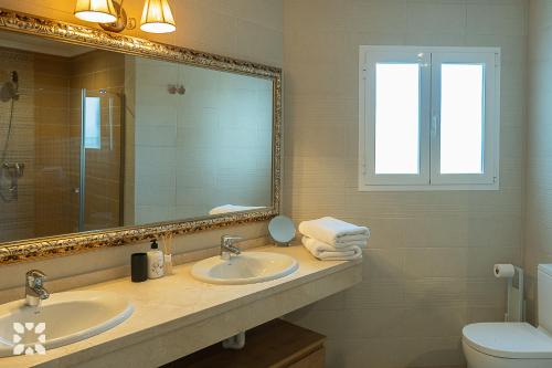 ベニタチェルにあるVilla Casiopea by Abahana Villasのバスルーム(洗面台2台、鏡、トイレ付)