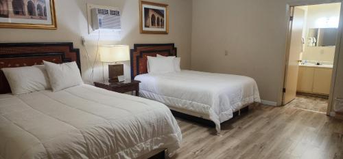a hotel room with two beds and a bathroom at Badlands Hotel & Campground in Interior