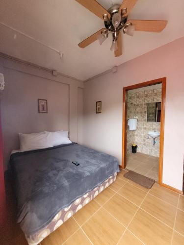 a bedroom with a bed and a ceiling fan at J & V Oceanview Beach Resort in Lalauigan