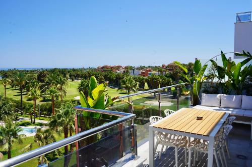 a balcony with a table and chairs and palm trees at Playa Granada Apartamentos Moriscos II in Motril