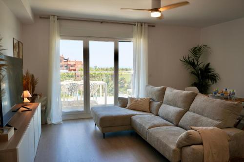 a living room with a couch and a sliding glass door at Playa Granada Apartamentos Moriscos II in Motril