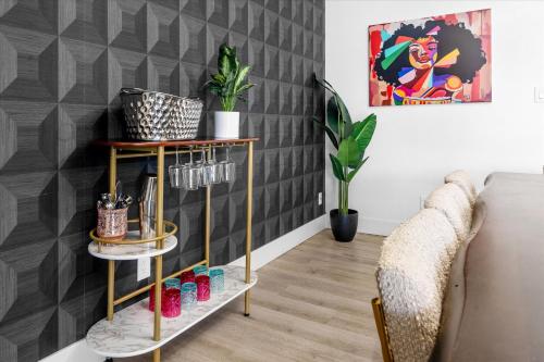 a living room with a gold and black accent wall at Mini Golf Fire Pit Pool Game Room in Chandler