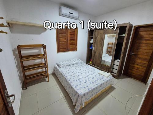 a small bedroom with a bed and a mirror at Casa na praia com vista para o mar in Luis Correia