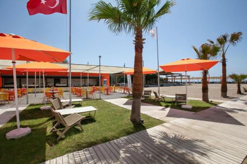 a patio with tables and chairs and umbrellas at Megasaray Resort Side in Side