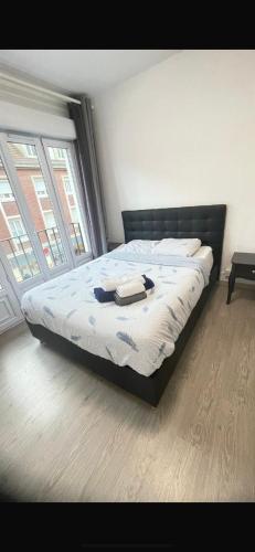 - un lit dans une chambre avec 2 fenêtres dans l'établissement Chambre double, à Beauvais