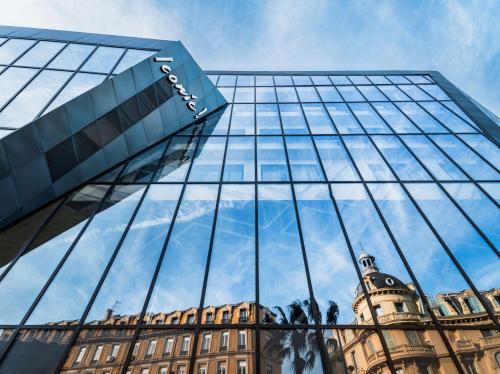 a reflection of a building in the glass of a building at Doubletree By Hilton Nice Centre Iconic in Nice