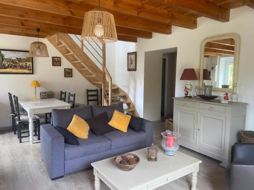 un salon avec un canapé bleu et une table dans l'établissement La petite maison dans la prairie, à Plouay