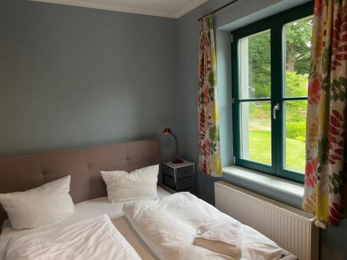 滨湖克拉科Ruhige Ferienwohnung mit großem Garten und Terrasse的卧室里有一张铺着白色床单的床和一扇窗户