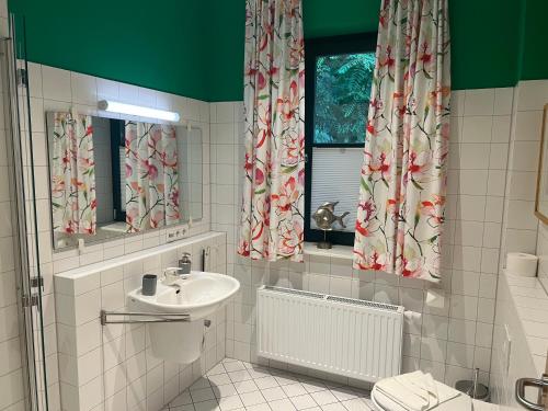 滨湖克拉科Ruhige Ferienwohnung mit großem Garten und Terrasse的带水槽和窗户的白色浴室