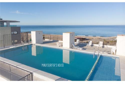a swimming pool with the ocean in the background at Maui Surfer's House Sea view Caparica Beach House in Costa da Caparica