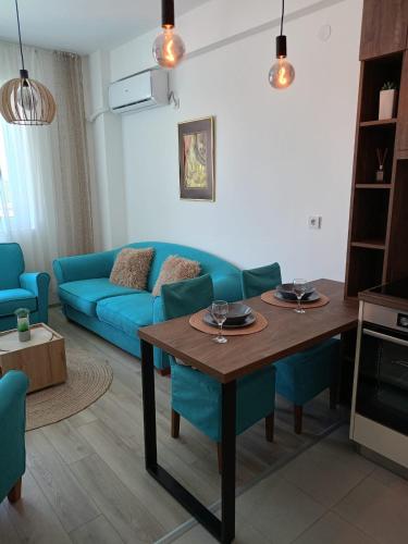 a living room with a blue couch and a table at Jagodina Apartman Nastasija- gleda na Aqva park in Jagodina