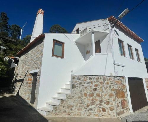 a white building with a lighthouse on top of it at Casa Vila Rosa in Penacova