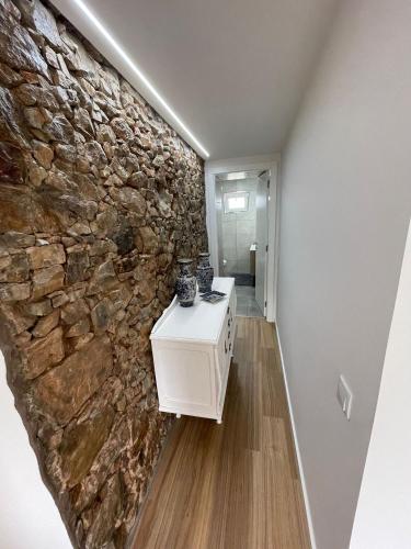 a room with a stone wall and a white counter at Casa Vila Rosa in Penacova