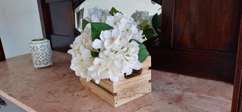 a wooden vase with white flowers on a table at Casa Vila Rosa in Penacova
