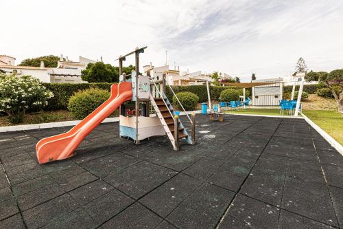 einen Spielplatz mit einer roten Rutsche auf dem Dach in der Unterkunft Marrocha II in Lagoa