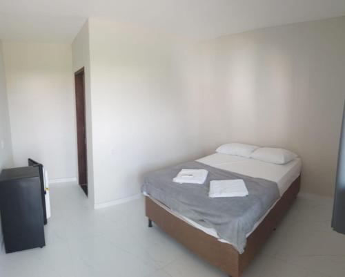 a bedroom with a bed with two towels on it at Pousada Sophia Beach in Salinópolis