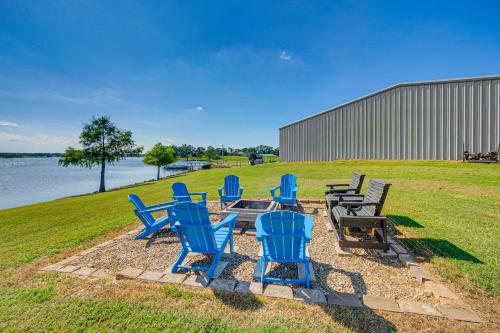 a group of blue chairs and a table next to the water at Van Vacation Retreat with Private 300-Acre Lake! in Van