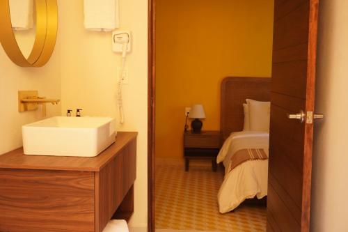 a bathroom with a sink and a bed at Casa Martina Guest House in Pátzcuaro