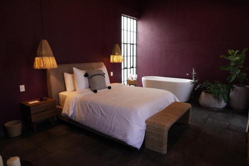 a bedroom with a large bed and a bath tub at Casa Martina Guest House in Pátzcuaro
