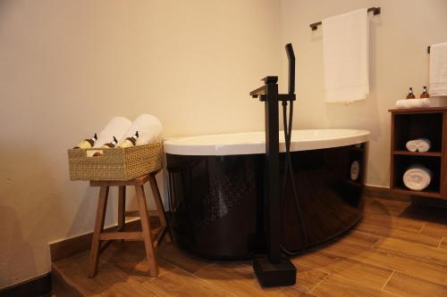 a bath tub in a bathroom with a basket of towels at Casa Martina Guest House in Pátzcuaro