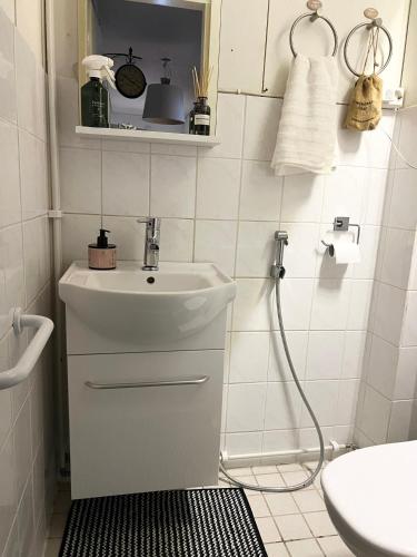 een witte badkamer met een wastafel en een douche bij Kaksio paritalossa in Mikkeli