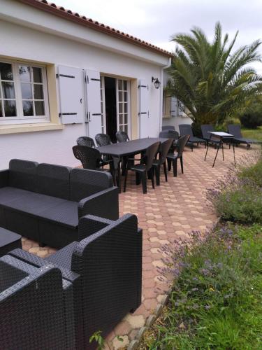 un groupe de tables et de chaises noires sur une terrasse dans l'établissement Familly, à Avrillé