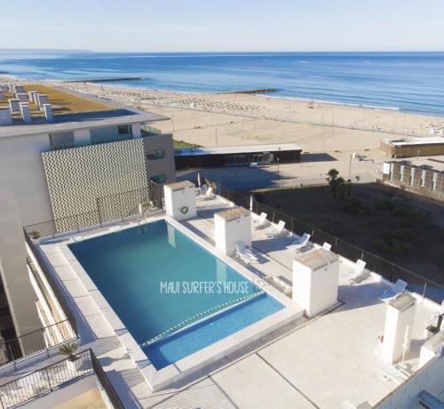 an overhead view of a swimming pool and the beach at Maui Surfer's House Sea view Caparica Beach House in Costa da Caparica