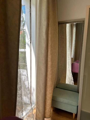 a mirror and a chair in front of a window at Apartment mit Gartenblick und Terrasse in Baden