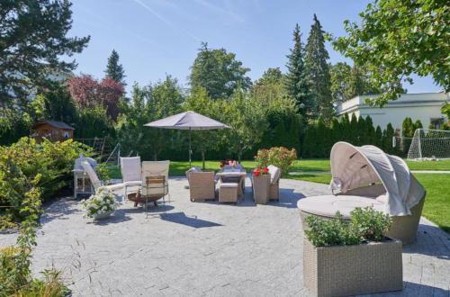 a patio with chairs and a table and an umbrella at Apartment mit Gartenblick und Terrasse in Baden