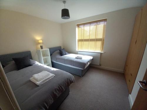 a bedroom with two beds and a window at Comfortable and spacious 2 bedrooms Free parking in Nottingham