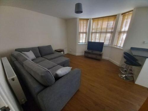 a living room with a couch and a flat screen tv at Comfortable and spacious 2 bedrooms Free parking in Nottingham