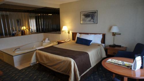 a hotel room with a bed and a bath tub at Travelodge by Wyndham Niagara Falls At the Falls in Niagara Falls